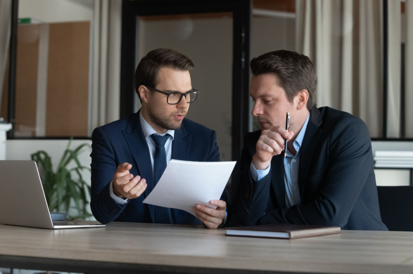 Image of two male business colleagues having discussion in modern office environment.