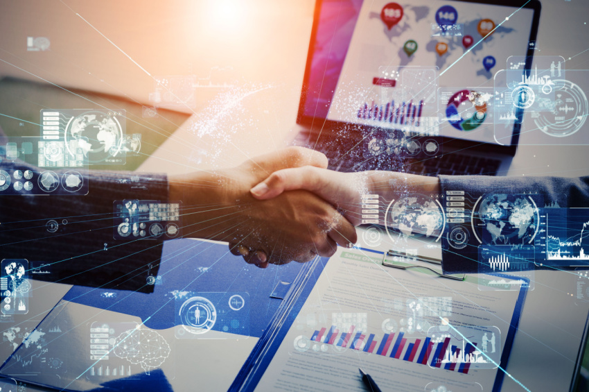 Business men shaking hands depicting business technology communication network.