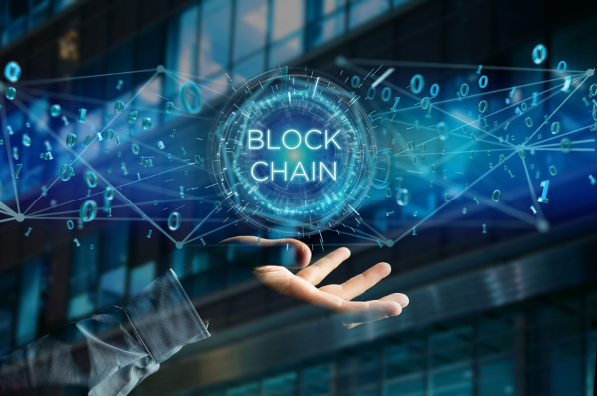 Double exposure view of a businessman holding digital Blockchain title with 0 and 1 data flying over