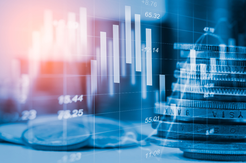 A stock market trading graph with a pile of coins illustrates the Fintech stocks investments concept.