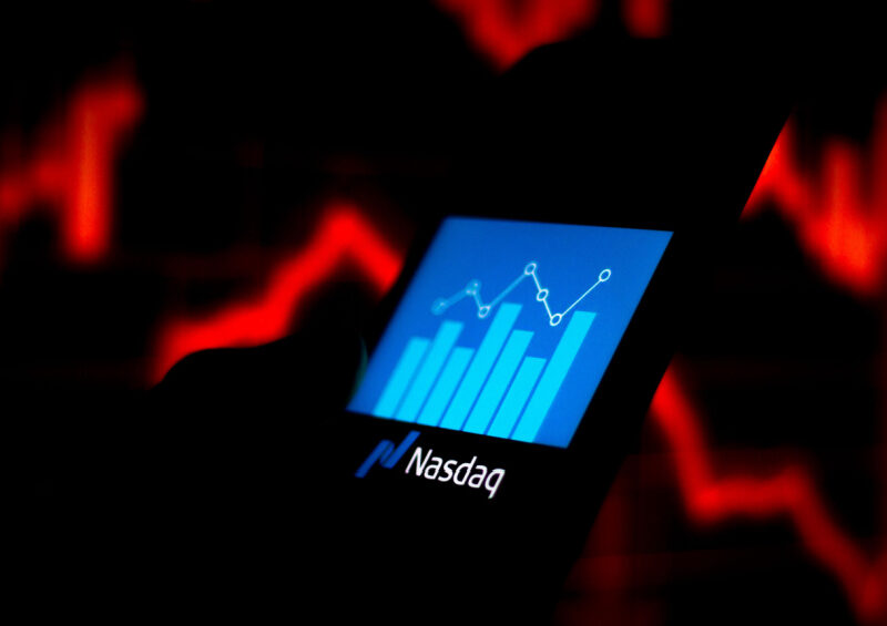 The Nasdaq logo seen displayed with a stock growth bar chart on a smartphone illustrates the risks & consequences of Nasdaq delisting.