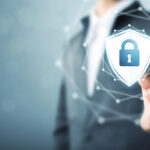 A businessman touching a shield protect icon illustrates the concept of fraud prevention in trade finance.