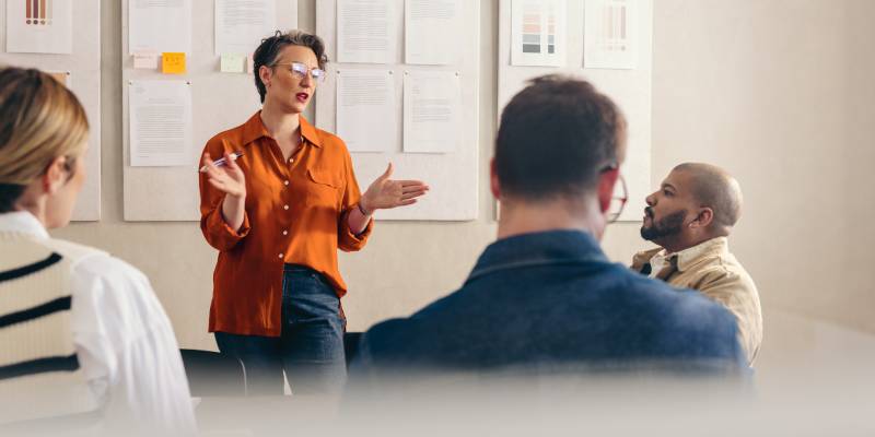 A businesswoman discussing their startup pitch strategies to her team during a meeting.