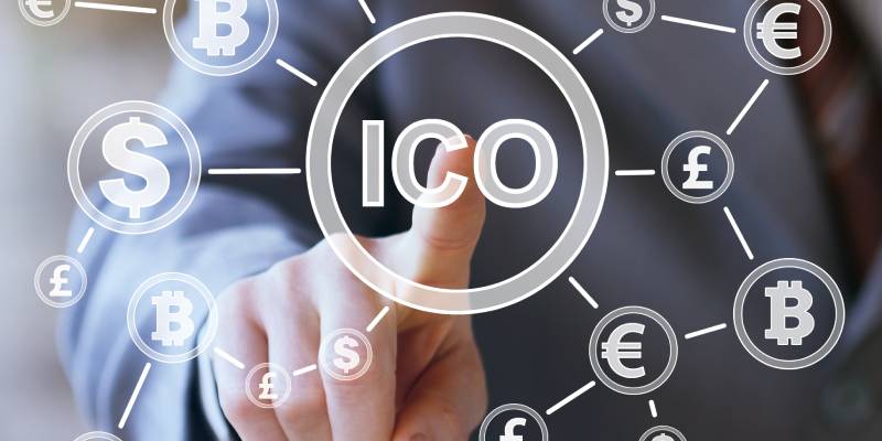 A person touching the term ICO mentioned in the virtual screen in front of him and symbols of various currencies and crypto currencies are shown around.