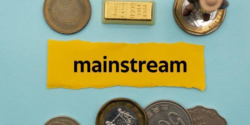 The word "Mainstream" is written on a slip of paper along with few coins and a gold bar kept around it.