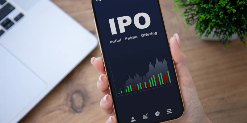 A female hand holding a phone with IPO stocks purchase app on screen.