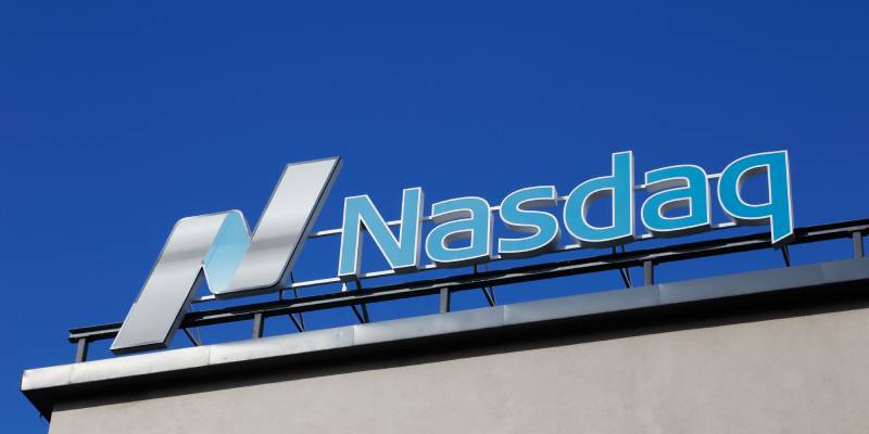 Image of a roof sign board of NASDAQ on a building along with the logo.