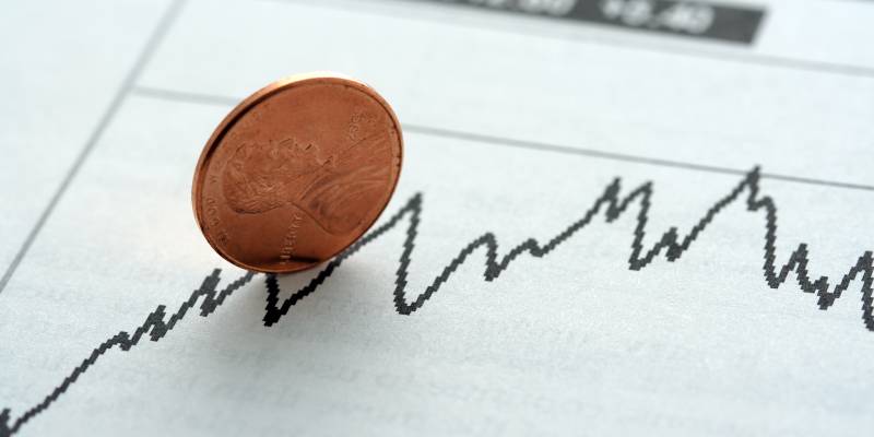 Image of a penny kept vertically on a graph related to a stock.