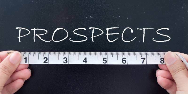 Image of the term prospects displayed on a blackboard and two hands holding a measuring tape below it.