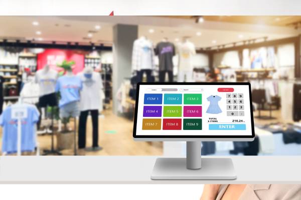 A touch screen cash register on white desk with blurred supermarket as background